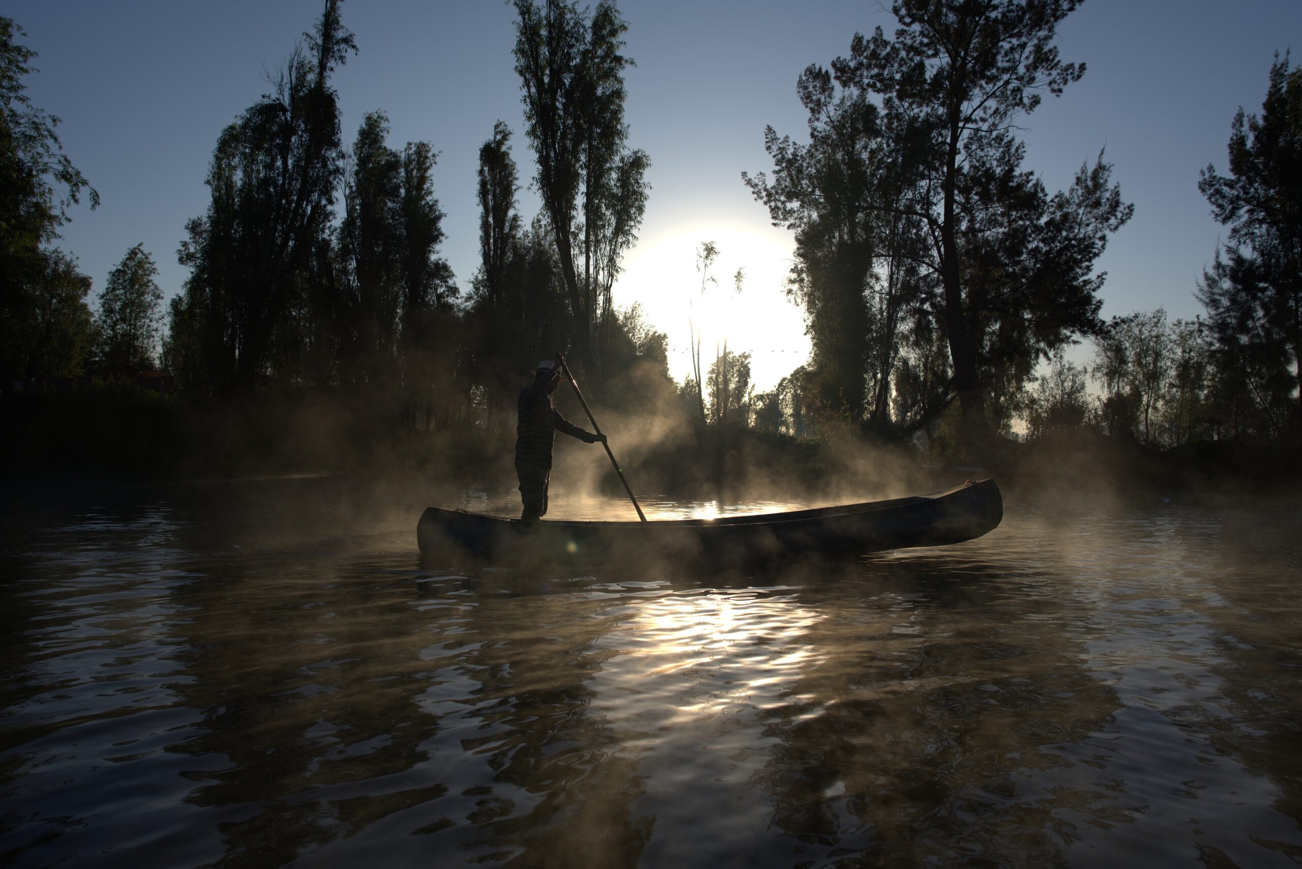 person canoing on misty water